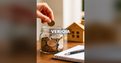 Hand placing a coin into a glass emergency savings jar beside a notebook