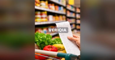 Grocery shopper holding a receipt beside a cart of fresh food