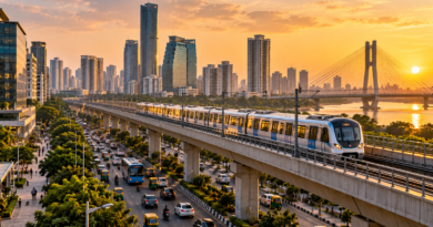 Metro train crossing an elevated track in a busy city at sunset